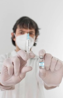 Doctor holding a vaccine bottle and syringe