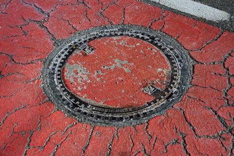Manhole cover in cracked asphalt