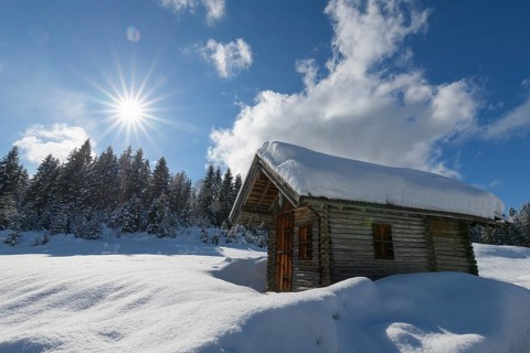 Winter landscape with wooden cabin