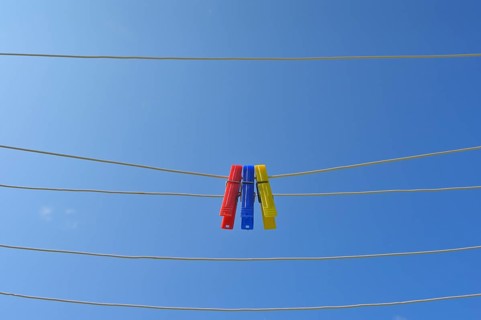 Clothesline with clothespins against blue sky