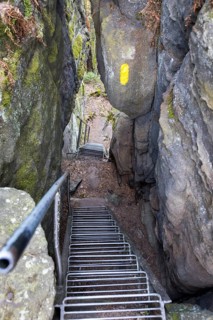 Hiking trail over stairs through narrow gorges between the rocks