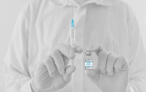 Doctor hands holding a vaccine bottle and syringe