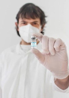 Doctor holding a vaccine bottle and syringe