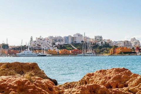 Marina in Portimao view through beautiful sandstone rocks in Ferragudo