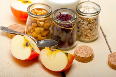 Healthy breakfast ingredients milk oat cashew nuts dried cramberry craisinns