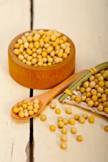 Organic soya beans over rustic wood table macro closeup