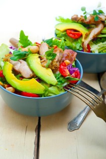 Fresh and healthy Chicken Avocado salad over rustic wood table