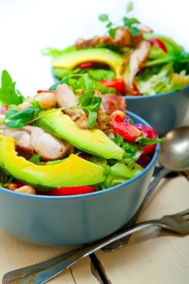 Fresh and healthy Chicken Avocado salad over rustic wood table