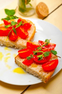 Italian tomato bruschetta with thyme and mint leaves