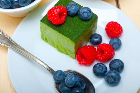 Green tea matcha mousse cake with raspberries and blueberries on top
