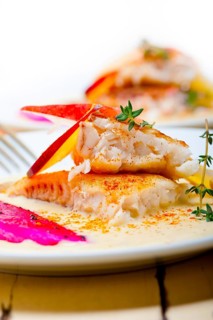 Sea bream orata fillet butter pan fried with fresh peach prune and dragonfruit slices thyme on top