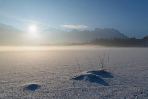 Frozen lake Barmsee with Karwendel mountainrange at sunrise in winter