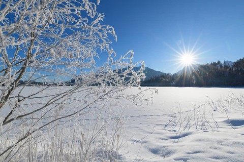 Frozen lake Barmsee with Karwendel mountainrange on morning with sun in winter