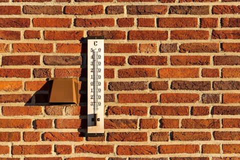 Thermometer on a red brick wall