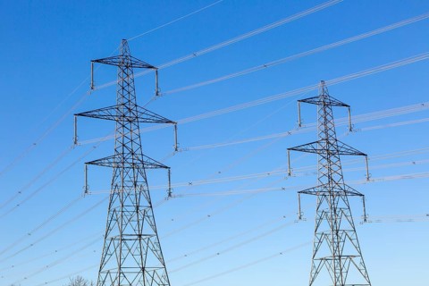 Electrical pylons and high voltage electricity transmission power lines from Sizewell nuclear power station against blue sky