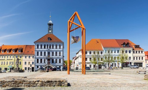 Steel sculpture on the market square with Paradise Fountain and town hall