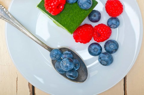Green tea matcha mousse cake with raspberries and blueberries on top