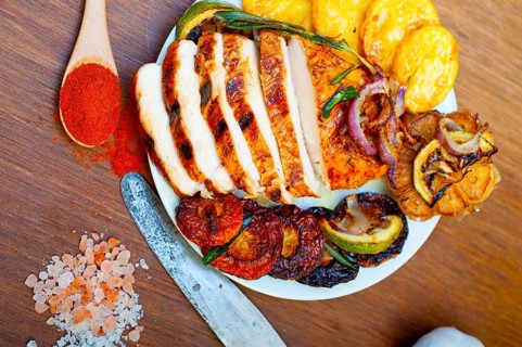 Roasted grilled BBQ chicken breast with herbs and spices rustic style