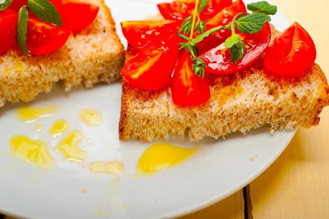 Italian tomato bruschetta with thyme and mint leaves