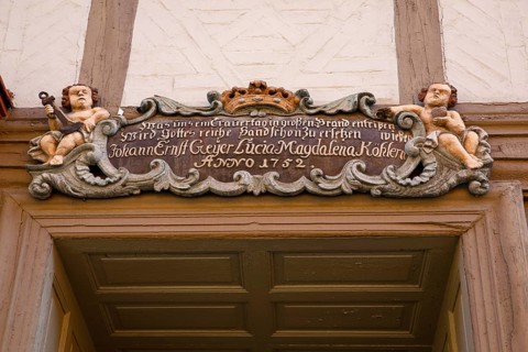 Baroque cartouche with putti above old wooden door