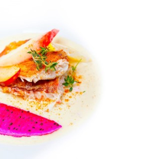 Sea bream orata fillet butter pan fried with fresh peach prune and dragonfruit slices thyme on top