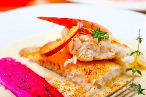 Sea bream orata fillet butter pan fried with fresh peach prune and dragonfruit slices thyme on top