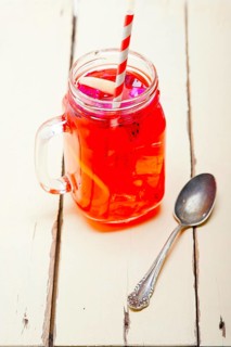 Fresh fruit punch refreshing summer drink over white rustic wood table