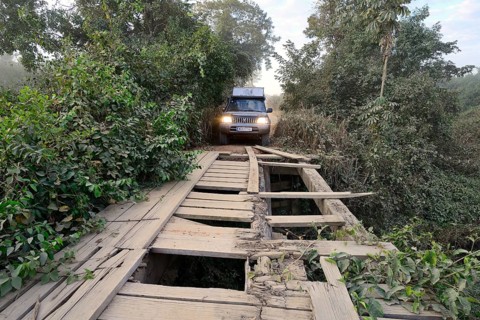 Off-road vehicle in front of a broken wooden bridge on the Transpantaneira