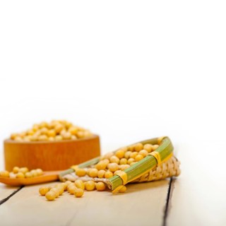 Organic soya beans over rustic wood table macro closeup