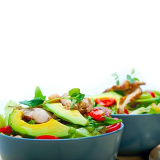 Fresh and healthy Chicken Avocado salad over rustic wood table