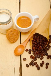 Espresso coffee and beans on a paper cone cornucopia over white background