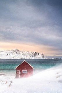 Red Rorbuer fishing hut on the beach in the snow