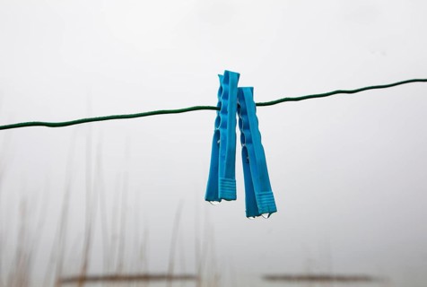 Clothes pegs on a rope with water drops