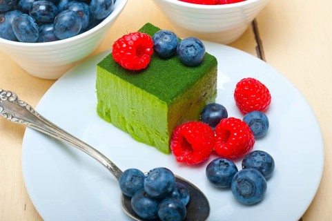 Green tea matcha mousse cake with raspberries and blueberries on top