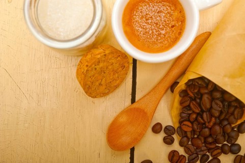 Espresso coffee and beans on a paper cone cornucopia over white background