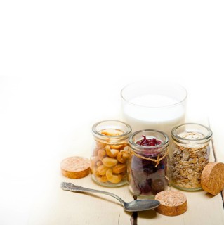 Healthy breakfast ingredients milk oat cashew nuts dried cramberry craisinns