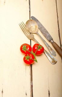 Ripe cherry tomatoes cluster over white rustic wood table