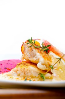 Sea bream orata fillet butter pan fried with fresh peach prune and dragonfruit slices thyme on top