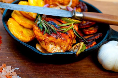 Roasted grilled BBQ chicken breast with herbs and spices rustic style on iron skillet