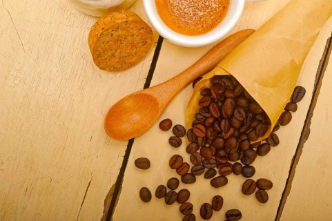 Espresso coffee and beans on a paper cone cornucopia over white background