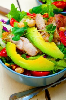 Fresh and healthy Chicken Avocado salad over rustic wood table