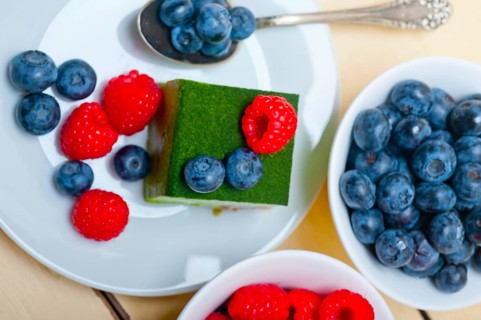 Green tea matcha mousse cake with raspberries and blueberries on top