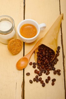 Espresso coffee and beans on a paper cone cornucopia over white background