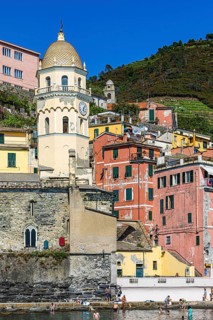 The church of Santa Margherita di Antiochia and nested houses built into the hillside with pastel-coloured facades