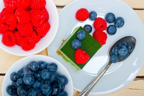 Green tea matcha mousse cake with raspberries and blueberries on top