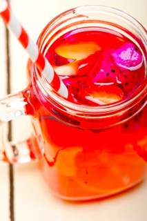 Fresh fruit punch refreshing summer drink over white rustic wood table