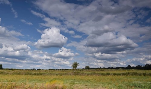 Former sewage field and blue sky with clouds in Gatow