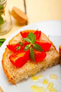 Italian tomato bruschetta with thyme and mint leaves