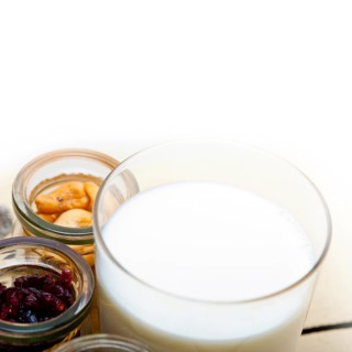 Healthy breakfast ingredients milk oat cashew nuts dried cramberry craisinns