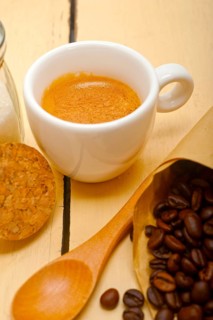Espresso coffee and beans on a paper cone cornucopia over white background